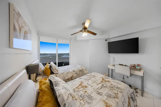 a bedroom with a bed and a flat tv screen on the dresser