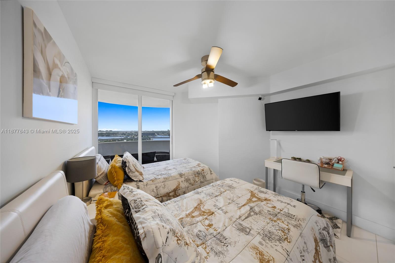 6301 Collins Avenue, Unit 2107 Miami Beach, FL 33141 - Photo 21 of 42 a bedroom with a bed and a flat tv screen on the dresser