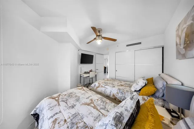 a bedroom with a bed and a flat screen tv