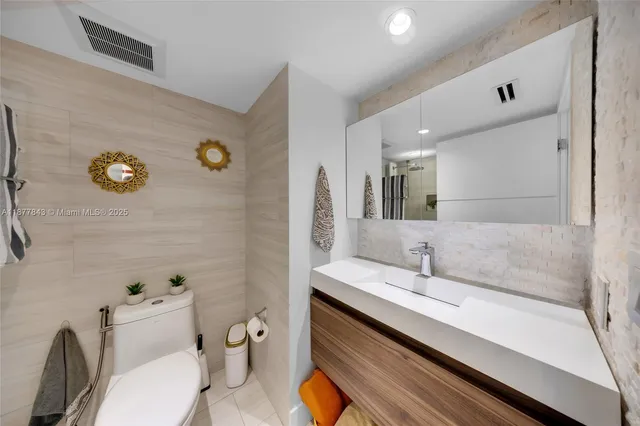 a bathroom with a sink mirror and toilet