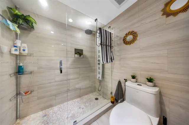 a bathroom with a toilet and a shower