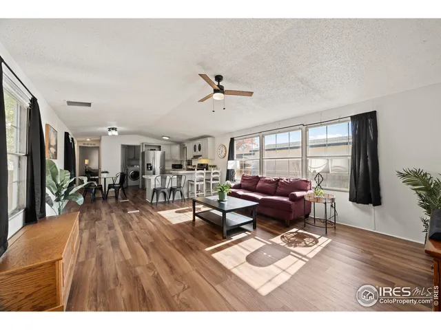 a living room with lots of furniture wooden floor and a table