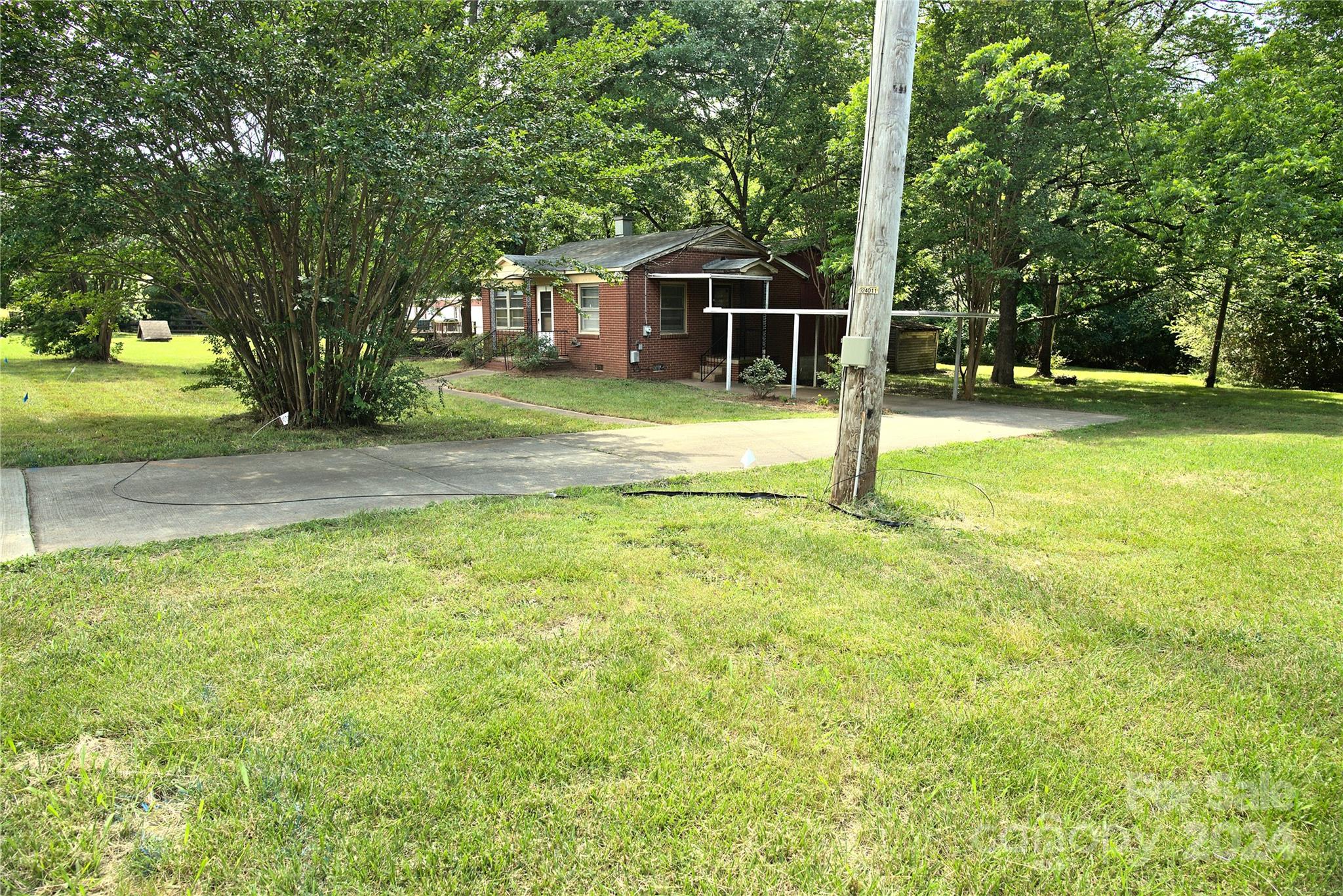 14903 Beatties Ford Road Huntersville, NC 28078 - Photo 7 of 25 a view of a house with backyard and tree