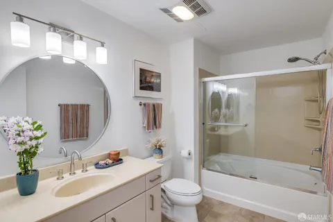 a spacious bedroom with a bed and painting on the wall