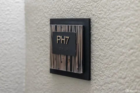 a dining room with furniture a potted plant and kitchen view