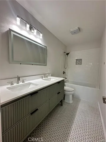 a bathroom with a double vanity sink mirror and toilet