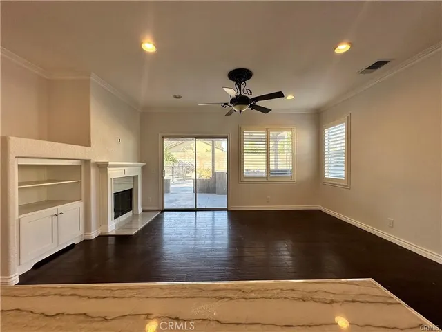 a view of an empty room with a fireplace and a window