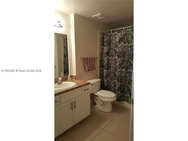 a bathroom with a toilet a sink and a mirror