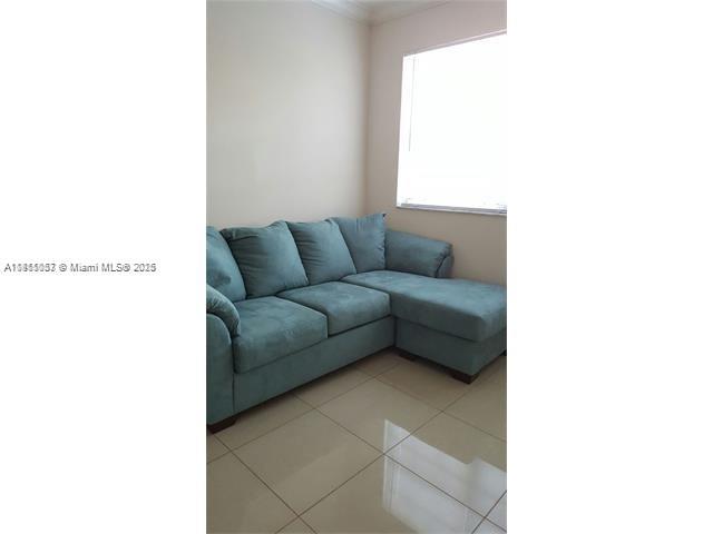 140 Southwest 117th Avenue, Unit 4101 Pembroke Pines, FL 33025 - Photo 5 of 8 a living room with furniture and a window