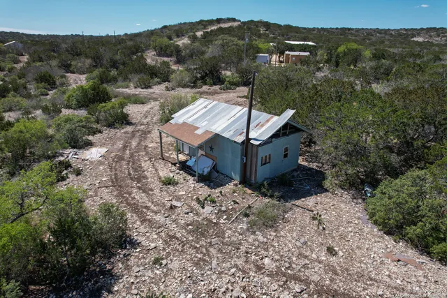an aerial view of a house with a mountain