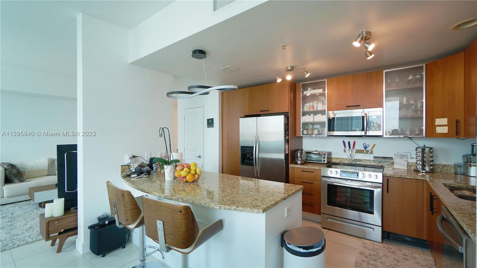 a kitchen with stainless steel appliances granite countertop a stove refrigerator and cabinets