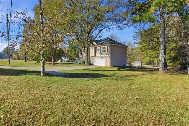a view of a house with a big yard and large trees