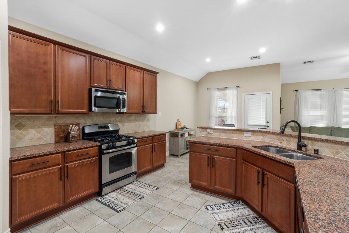 4926 Magnolia Bend Drive Rosharon, TX 77583 - Photo 11 of 27 a kitchen with stainless steel appliances granite countertop wooden cabinets a sink and dishwasher a stove top oven with wooden floor