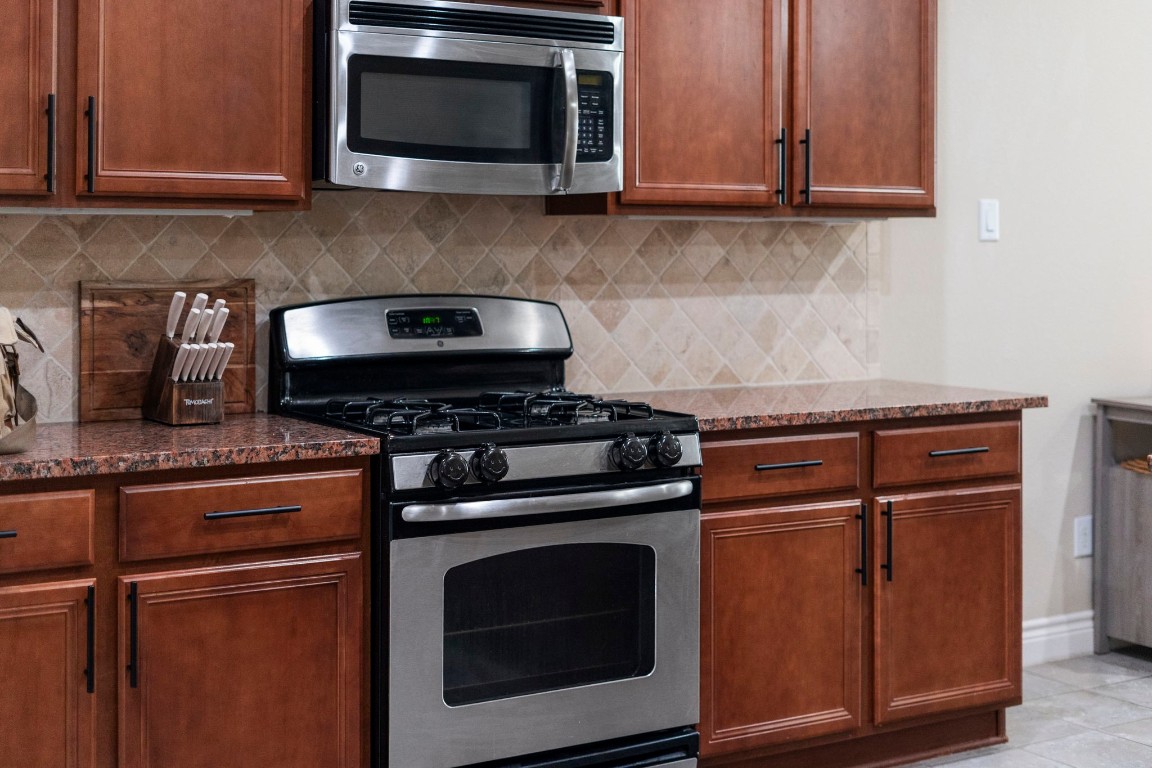 4926 Magnolia Bend Drive Rosharon, TX 77583 - Photo 12 of 27 a kitchen with wooden cabinets and a stove top oven