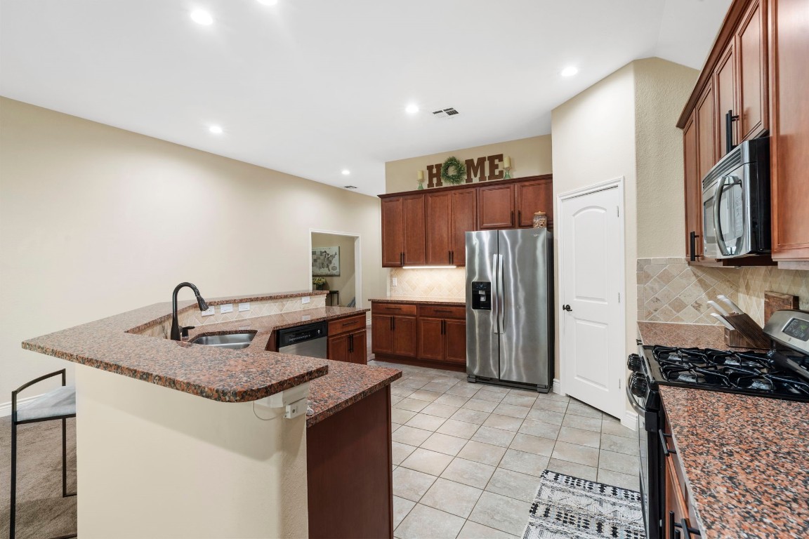 4926 Magnolia Bend Drive Rosharon, TX 77583 - Photo 10 of 27 a kitchen with stainless steel appliances granite countertop a sink stove and refrigerator