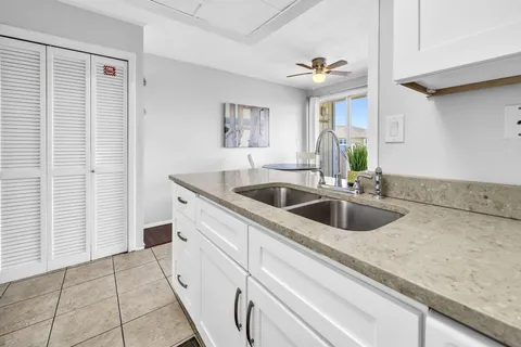 a kitchen with stainless steel appliances granite countertop a stove top oven a sink a dining table and chairs with wooden floor