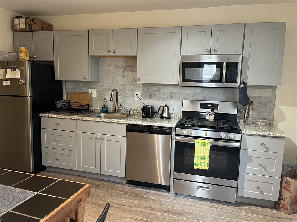 34 Clark Street, Unit 1 Somerville, MA 02143 - Photo 1 of 9 a kitchen with granite countertop white cabinets stainless steel appliances and a sink