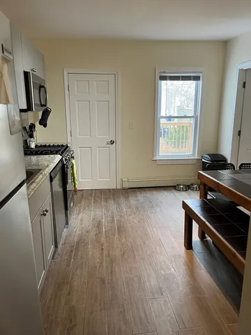 a livingroom with wooden floor and a window