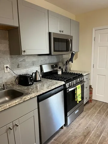 a kitchen with stainless steel appliances granite countertop a sink a stove a microwave and cabinets