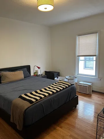 a bedroom with a bed and wooden floor