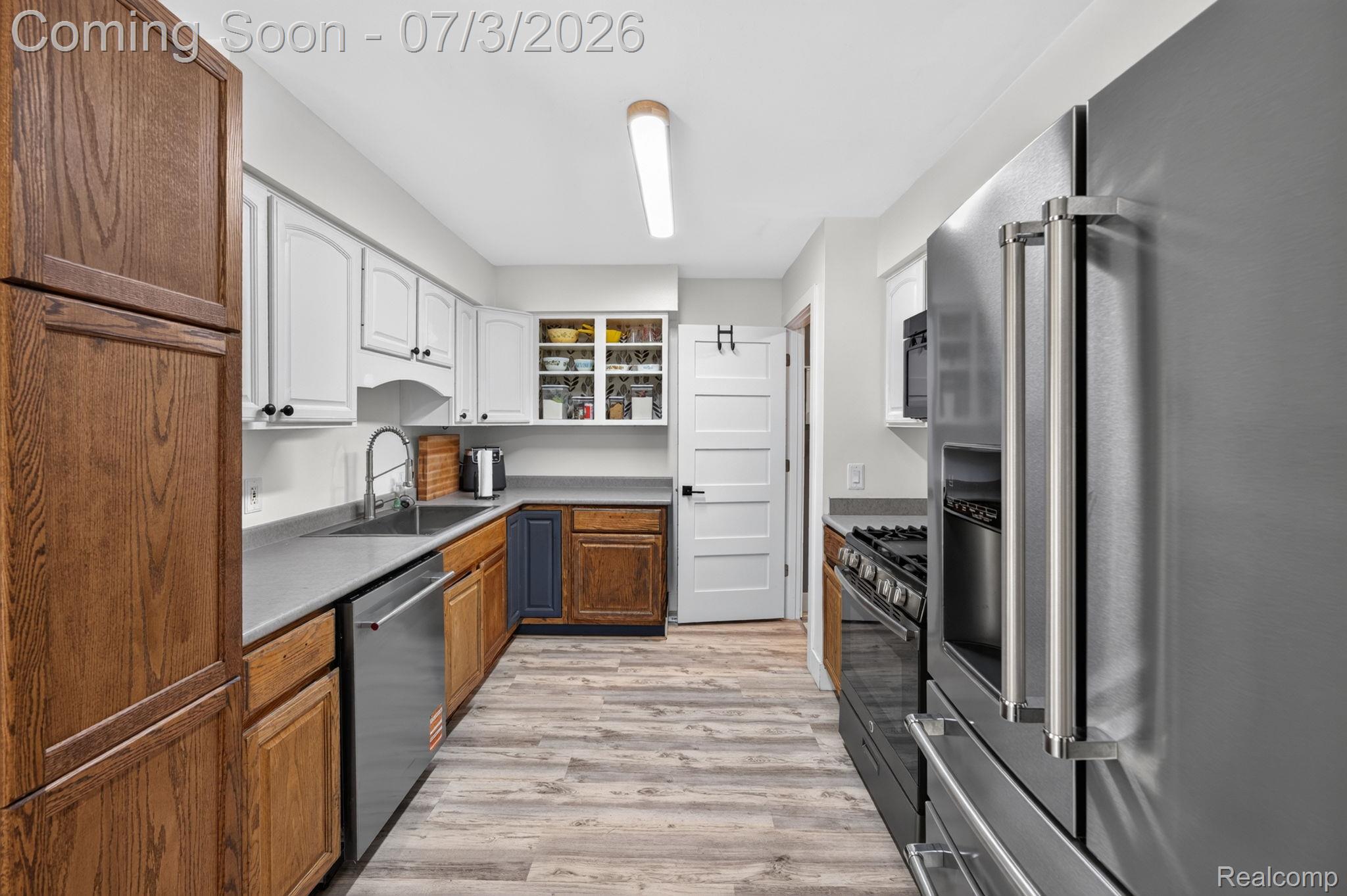 5355 North Seymour Road Flushing, MI 48433 - Photo 10 of 41 Galley kitchen featuring wood-finish flooring and a mix of white and natural wood cabinetry