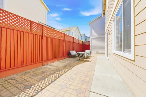 a view of a patio with a table and chairs and wooden fence