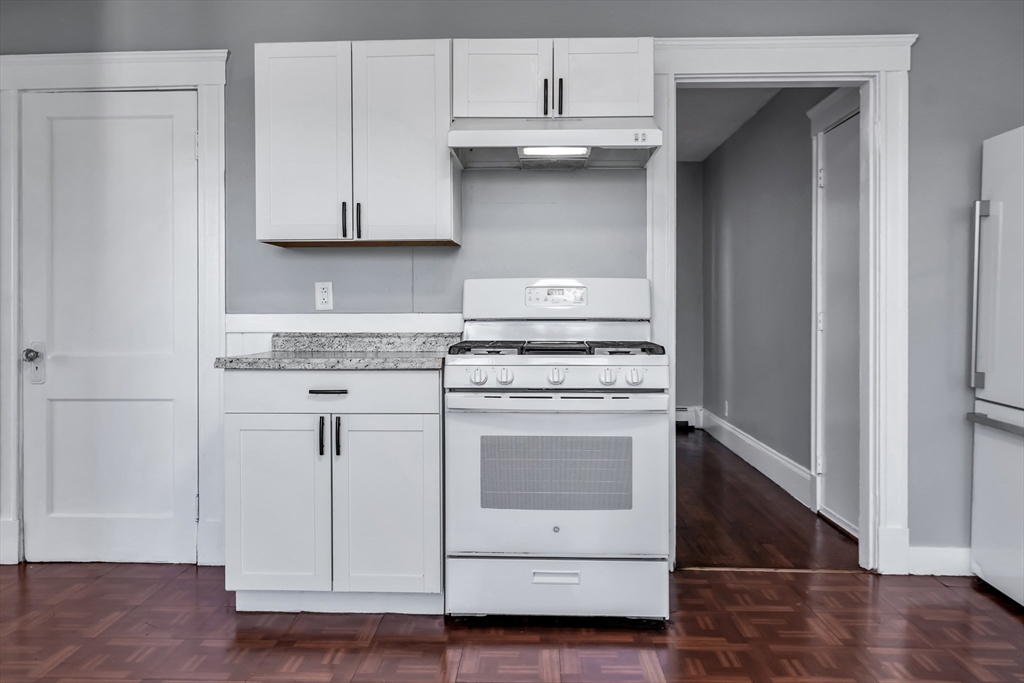 88 Congress Street, Unit 3 Salem, MA 01970 - Photo 10 of 31 a kitchen with granite countertop white cabinets and white appliances