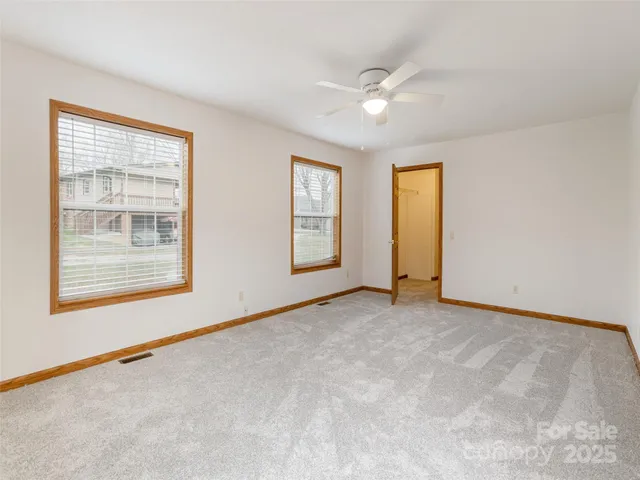 an empty room with windows and closet
