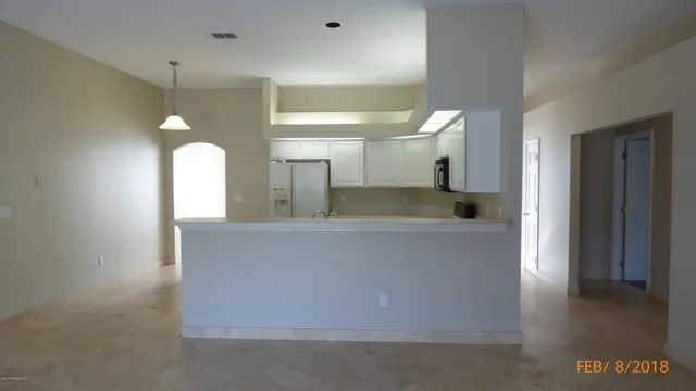 an empty room with a fireplace and chandelier fan