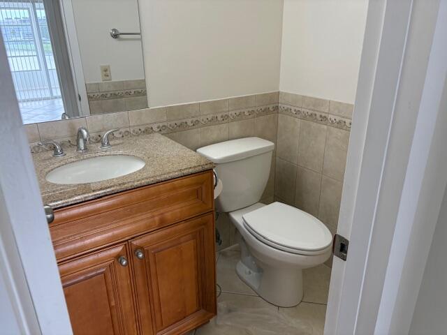 2035 Exeter, Unit 2035 Boca Raton, FL 33434 - Photo 7 of 15 a bathroom with a granite countertop toilet and a sink