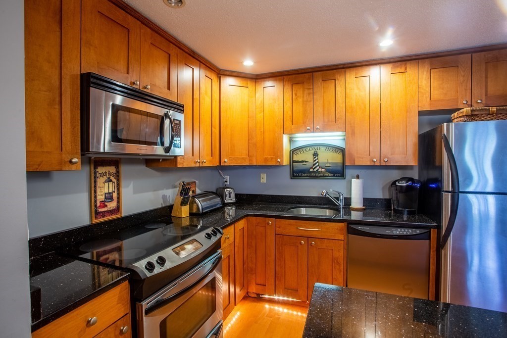 11 Church Street, Unit 101 Salem, MA 01970 - Photo 13 of 31 a kitchen with stainless steel appliances granite countertop a refrigerator a stove top oven a sink and dishwasher