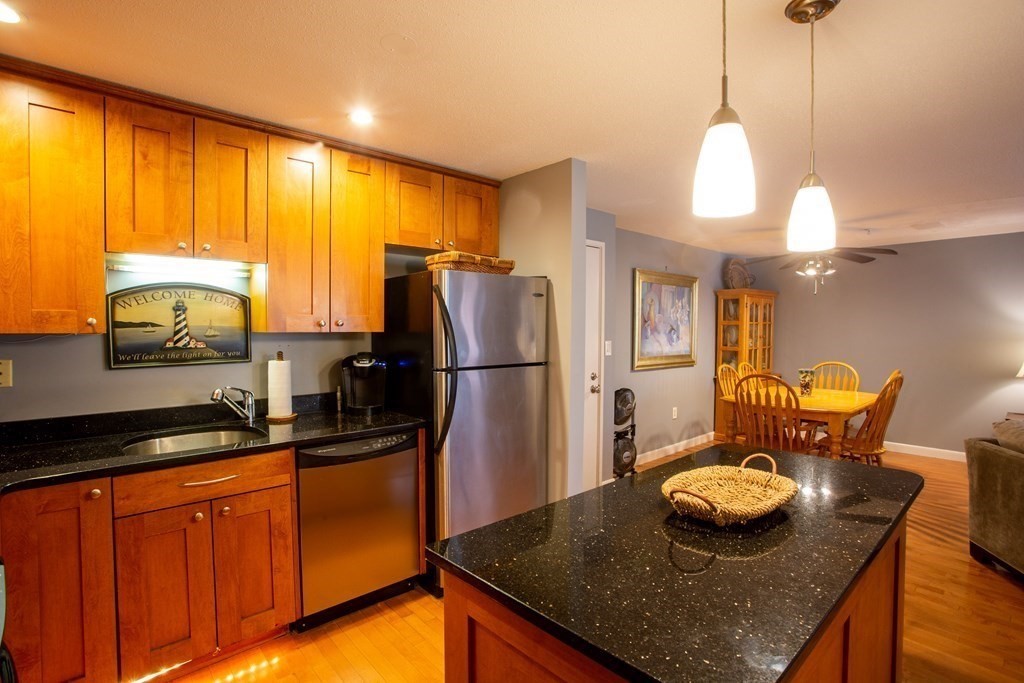 11 Church Street, Unit 101 Salem, MA 01970 - Photo 14 of 31 a kitchen with stainless steel appliances granite countertop a sink a refrigerator and wooden cabinets