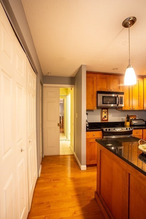 11 Church Street, Unit 101 Salem, MA 01970 - Photo 16 of 31 a kitchen with stainless steel appliances granite countertop a stove a sink and a refrigerator