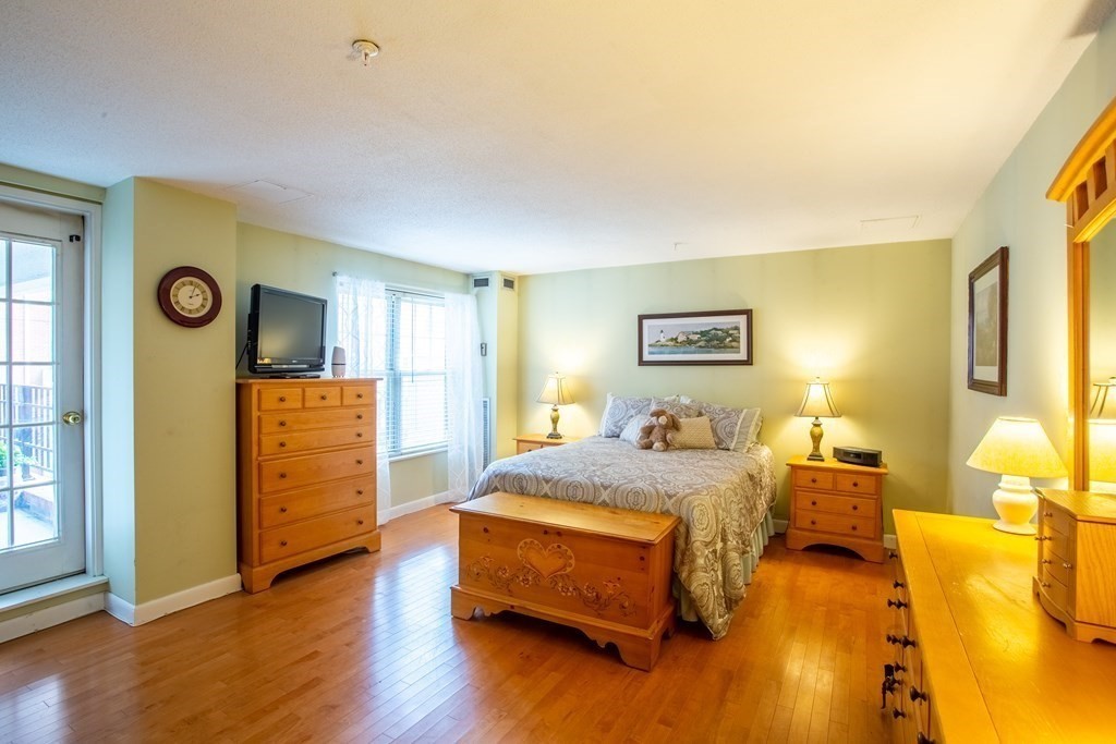 11 Church Street, Unit 101 Salem, MA 01970 - Photo 17 of 31 a bedroom with a bed and wooden floor