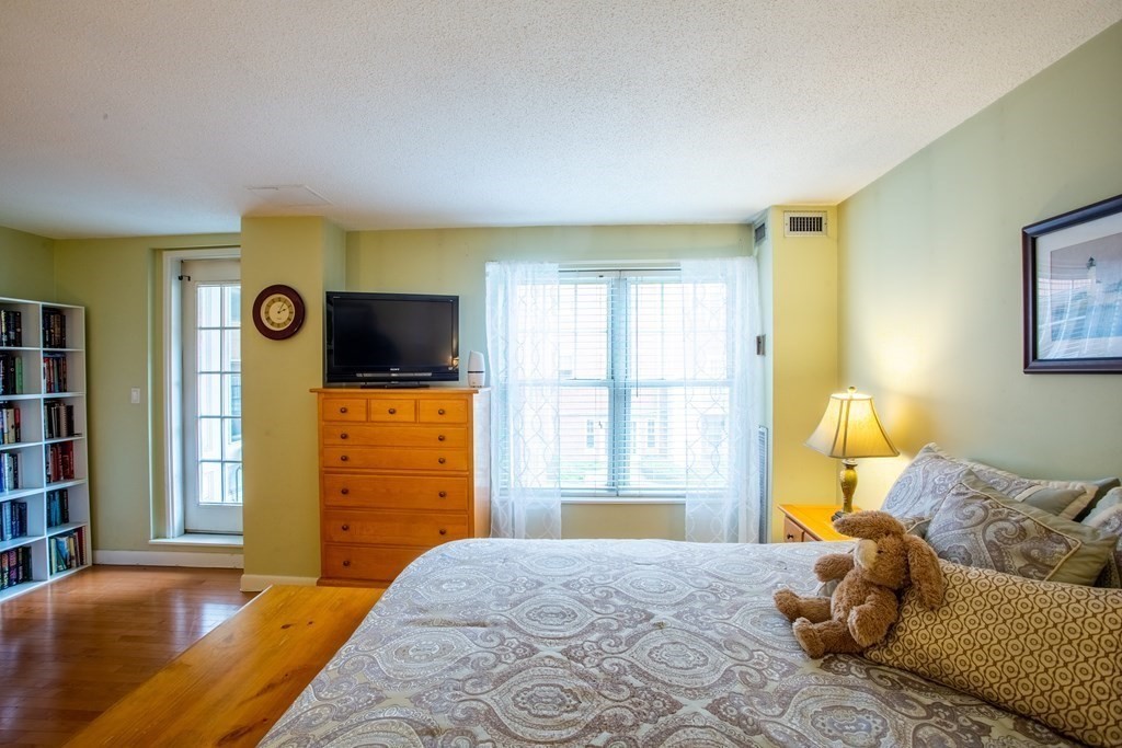 11 Church Street, Unit 101 Salem, MA 01970 - Photo 19 of 31 a bedroom with a bed and wooden floor