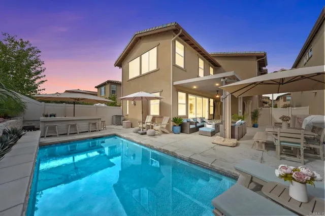 a view of a house with backyard and sitting area