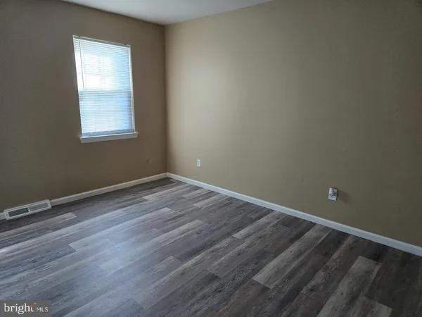 a view of a room with wooden floor and windows