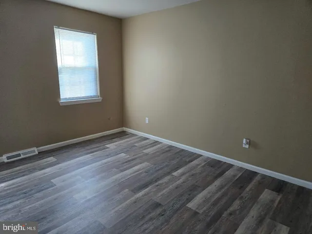 a view of a room with wooden floor and windows