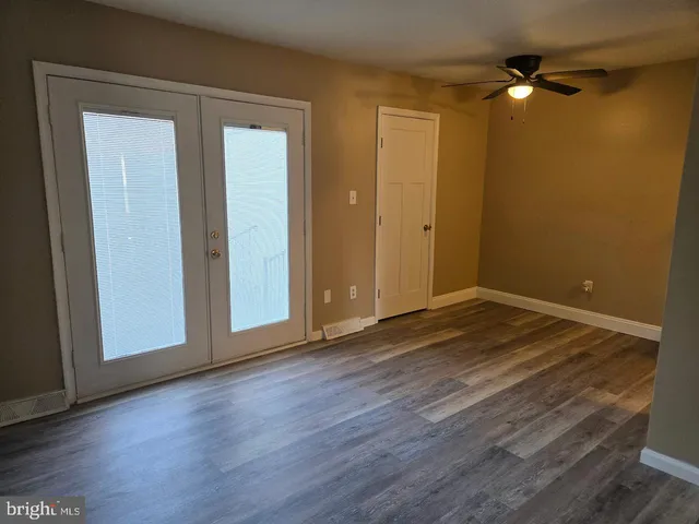 a view of an empty room with wooden floor