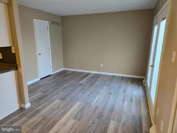 an empty room with wooden floor and a window