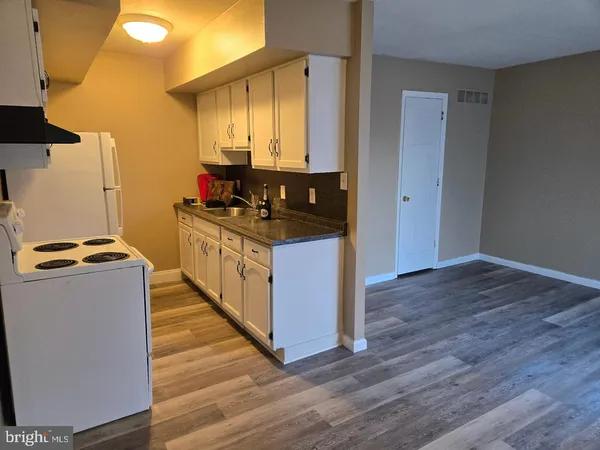 a kitchen with stainless steel appliances a stove and a wooden floor