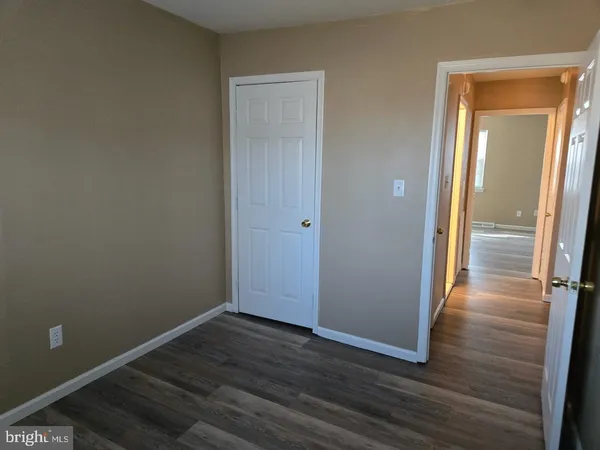 an empty room with wooden floor and entrance