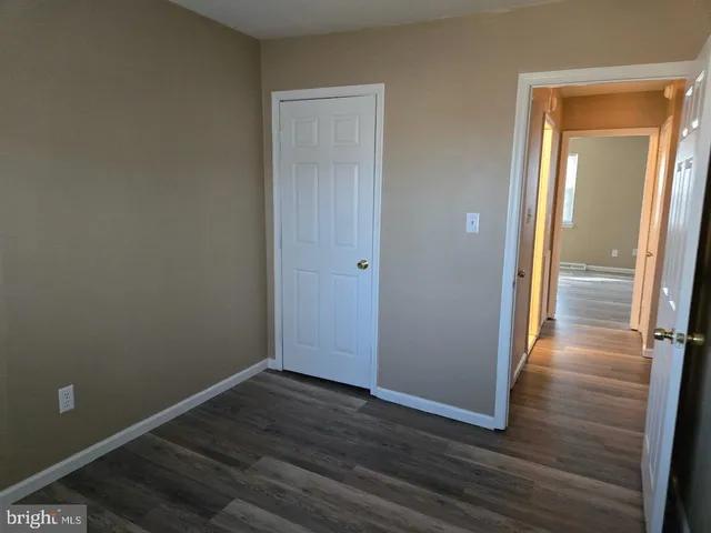 an empty room with wooden floor and entrance