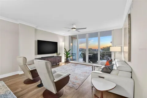 a view of a swimming pool with a lawn chairs under palm trees