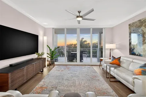 a living room with pool table flat screen tv and windows