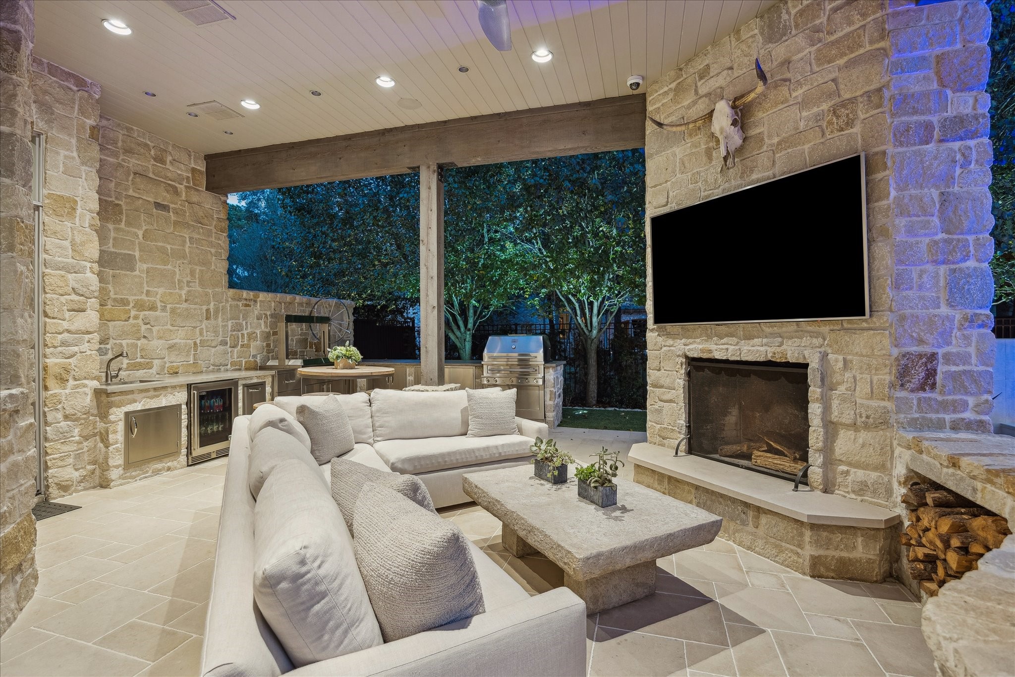 220 Merrie Way Lane Houston, TX 77024 - Photo 48 of 50 This outdoor retreat offers a wood-burning fireplace with built-in storage, Kalamazoo grilling equipment, and a mounted TV—ideal for al fresco living throughout the year.