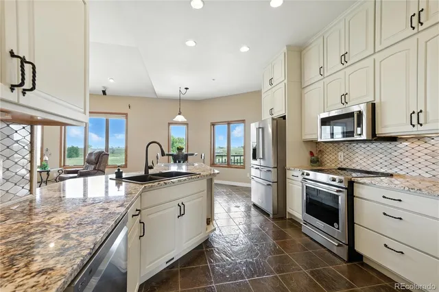 a kitchen with stainless steel appliances granite countertop a refrigerator and a stove