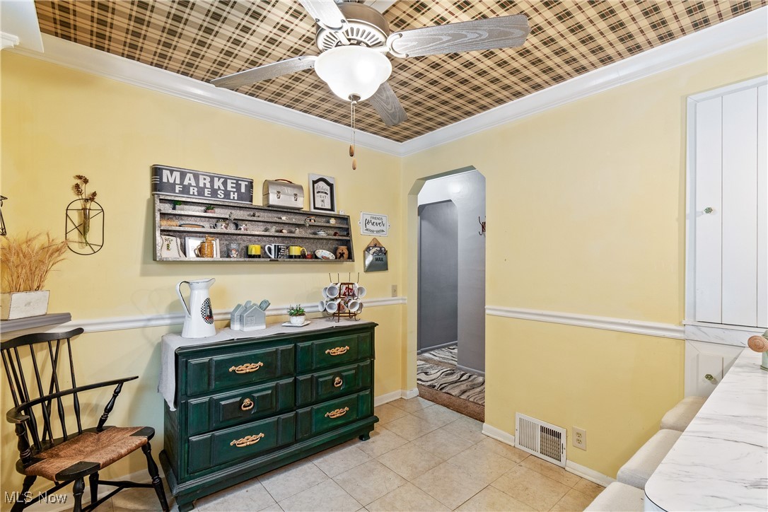 3589 Center Road Perry, OH 44081 - Photo 11 of 31 Bar featuring ceiling fan, crown molding, light tile patterned floors, and green cabinetry