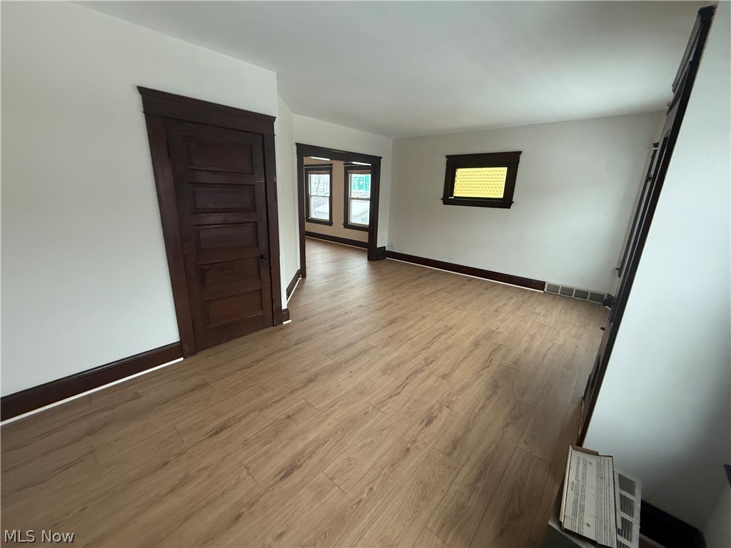3612 Riverside Avenue Cleveland, OH 44109 - Photo 11 of 22 Open-concept living space with wood-finish flooring, white walls, and dark wood trim