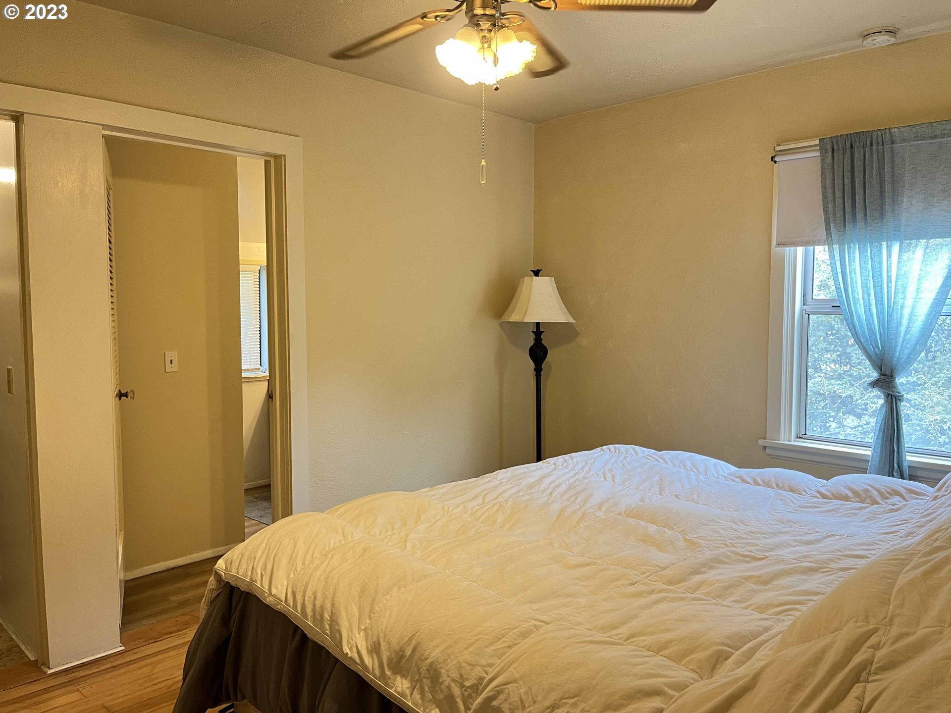 611 Laurel Street Florence, OR 97439 - Photo 24 of 32 a bedroom with a bed and a chandelier